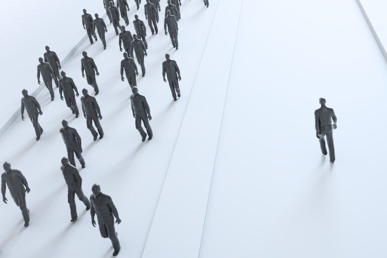 a crowd of individuals walking an opposite path from a lone individual, this symbolizes the stand some executives must make to uphold good c-suite ethics