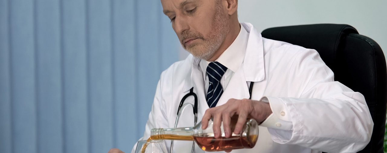 Tired doctor drinking alcohol after hard working day, stressful
