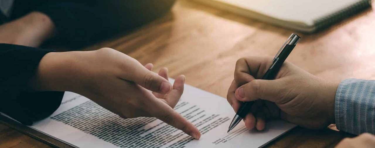 Manager pointing to signature line for employee to sign