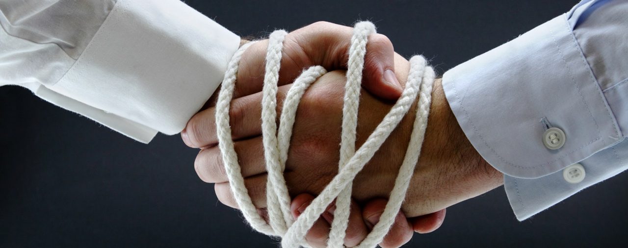 To illustrate what a legally binding contract is like, this image depicts two hands in agreement bound by a rope.